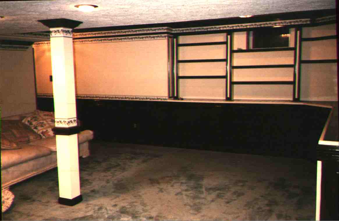 Finshed basement with built-in bookcases with tiled counters.&nbsp; Off to the left is the craft room.