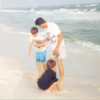 Jerry, James and Joshua digging in the sand near the edge of the ocean