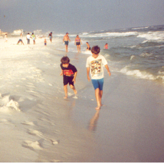 james and joshua walking on the beach in the wave breaks