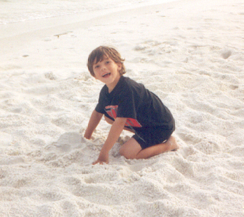 Joshua digging in the sand on the beach