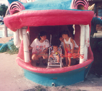 Jerry, James, Joshua and Marie sitting inside the mouth of a huge dragon at the miniature golf course.