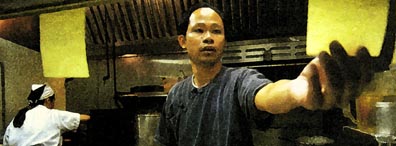 Caption: Cy working in kitchen.