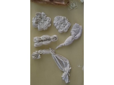 white garments that have been soaked in soda ash and tied ready to be dyed