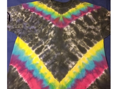 Rainbow colors centered on the shirt in the shape of a V with a blue/black background.