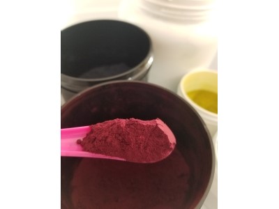 Large spoonful of dry purple dye