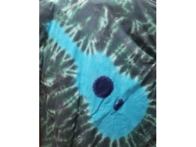 Blue guitar diagonally place d across the shirt with green background. 