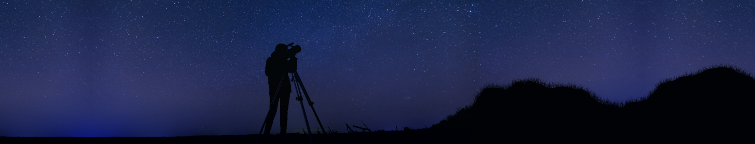 Person looking through telescope at the sky