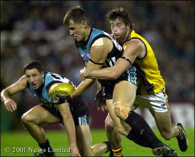 Jonathan Hay does a great tackle on Warren Tredrea