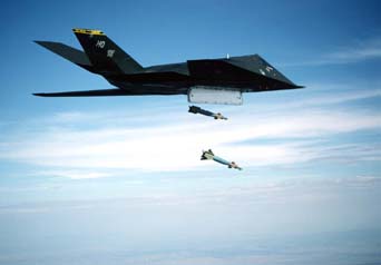 F117 releases two Laser Guided Bombs (LGB's) over a test range in the SW USA. The blue color indicates practice ordinance.