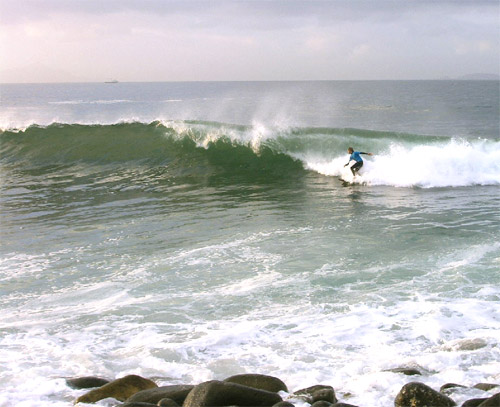 Here one of the surfers catching the "curl" within the white making a long ride.