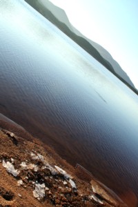 A lochside beach with chunks of ice on the sand.