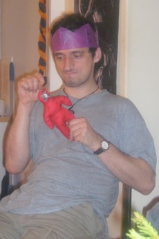 Alex angrily sticking pins into the doll, with a photo of our cranky downstairs neighbour on it.