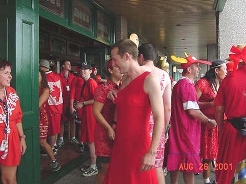 Daren in a red dress with other men and women clothed similarly