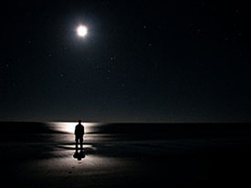 David Byers luminated by the moon at night on the beach