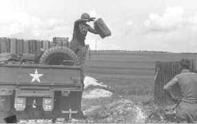Soldier unloading gasoline can from truck