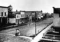 A street in Milwaukee, around 1860. Note dirt street and false front buildings.