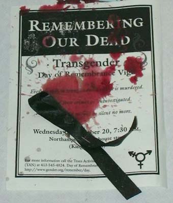 Picture of a Day of Remembrance flyer with blood on it and a black ribbon laying accross the flyer