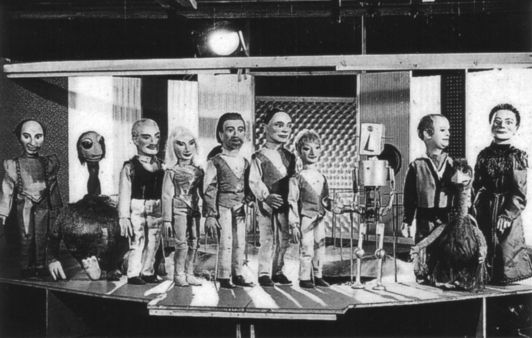 left to right: Jones the technician; Jo the Jovian; Colonel Raeburn; Marla; Captain Dart; Husky; Slim; a UGO robot; Professor Haggerty; Gabbler; the Martian President