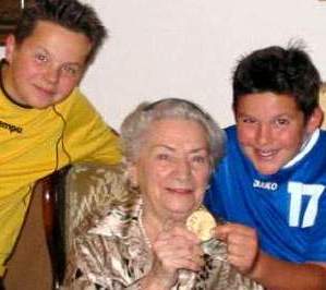 [Ottilie Grote-Fleischer kurz vor ihrem Tode 2005 mit ihren beiden Urenkeln und ihrer Goldmedaille, die sie irgendwie über den Krieg gerettet hat]