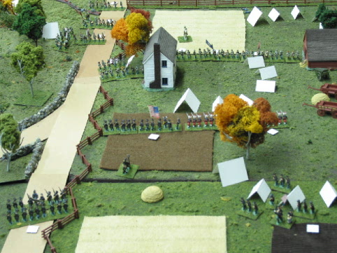 Veterian Confederate infantry advance across a farm. Facing them are green Union recruits.