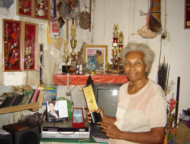 Ms. Ester Kereway (62), a West Papuan artist, with her trophies and some of her artworks hanging on the wall. This photo was shot by T.R. Dewi on May 31, 2006.