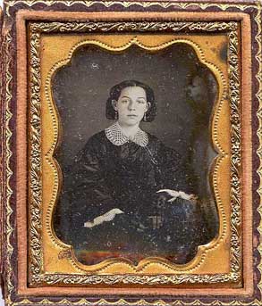 picture of young girl about sixteen with hair net, lace color, and earings. Dark dress.