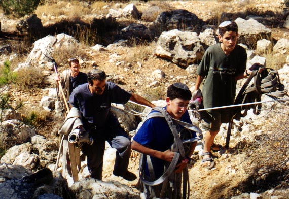 Dolev residents help to carry equpment after putting out the fire, 2001