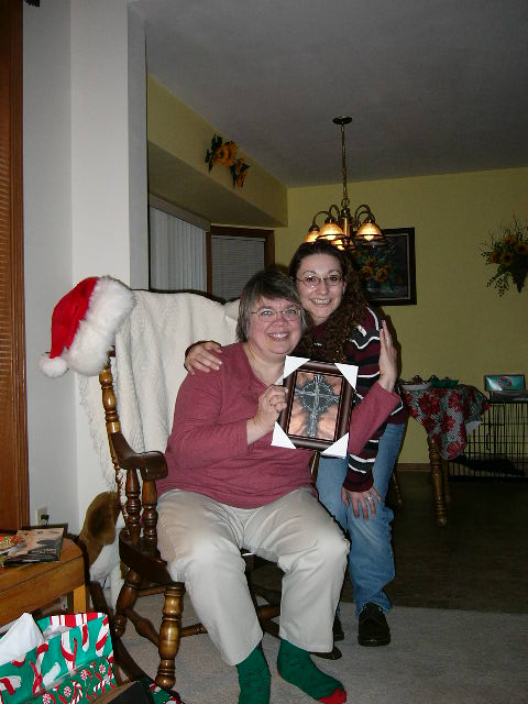 Kathy is holding up the Cross picture that Wendy made for her for a Christmas gift.