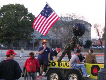 Brutus Buckeye holding up the American Flag