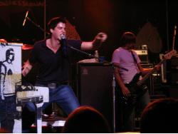 Andrew signaling to the audience with Clutch behind him