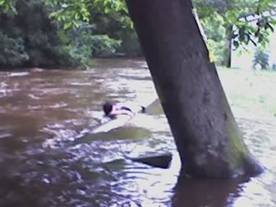 Josh the neighbor fell off his inner tube and clings to the wall to avoid being drug downstream