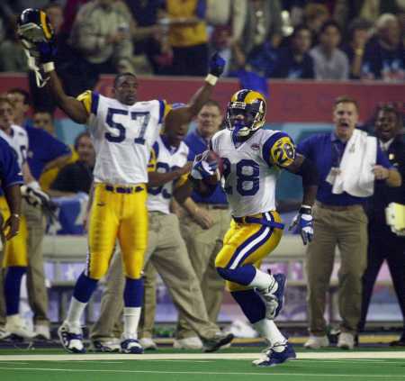 Faulk runs the ball with Little cheering from the side.