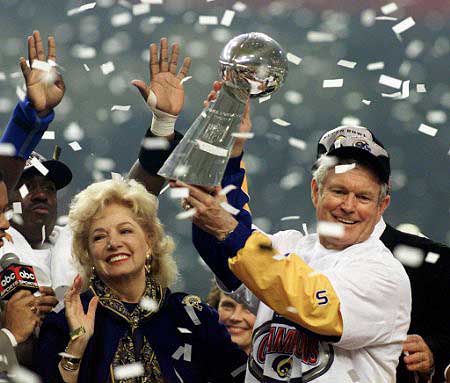 Coach Vermeil lofts the trophy and Georgia smiles as confetti rains down