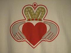 WHITE SHIRT WITH RED, GOLD AND GRAY CLADDAUGH ON THE FRONT AND WWW.EARTHBATTALION.COM IN GRAY ON THE BACK.