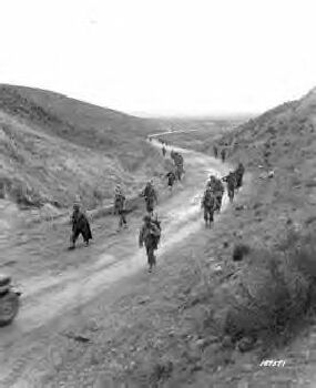 The 2nd Battalion, 16th Infantry, march through the Kasserine Pass and on to Kasserine and Farriana, Tunisia. 26 Feb 1943.