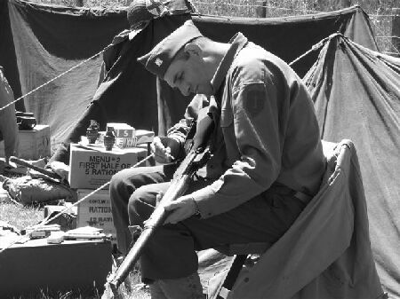 PVT EDWARDS CLEANING HIS RIFLE