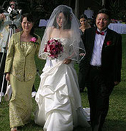 Parents leading Joyce in wedding dress