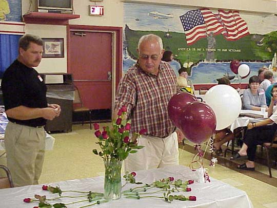 Steve Pryslopski presenting a rose in memory of a deceased classmate