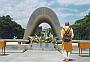 A monk prays at the peace memorial in Hiroshima. In the distance you can see the atomic dome.