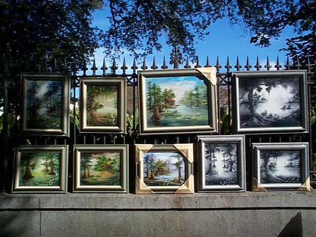 An artists' paintings hang along the fence surrounding Jackson Square in the French Quarter