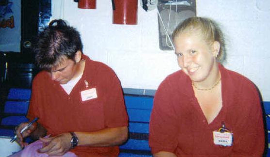 Erica, sitting as Steve takes this picture and John signs her "yearbook".