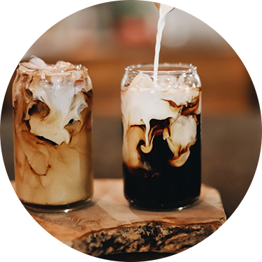 Cream Being Poured into Coffee in a Neck-less Cup