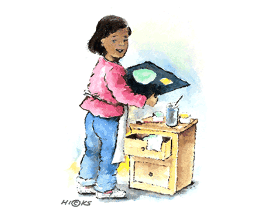 Picture of a girl who is painting on a table.
