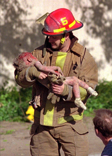 Firefighter Chris Fields carries little Baylee Almon (69K)