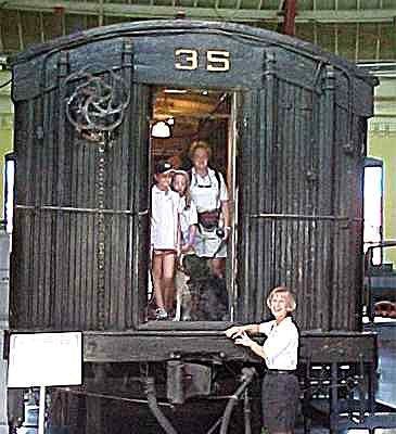 Puppy Raisers and pups inside an old Mail Car