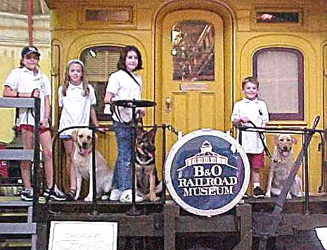 Sirius with friends standing on the rear deck of a caboose