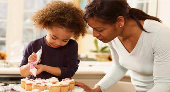Description: Description: Description: Description: Description: Photo of a woman and child decorating cupcakes.