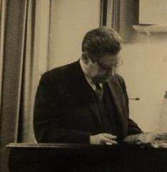 [Hans H. studiert eine Partitur]