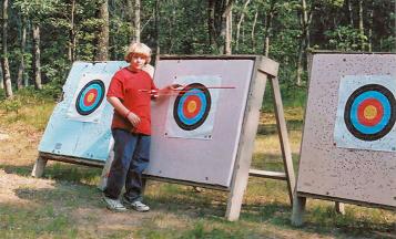 Picture of Scout in front of target at Archery Range