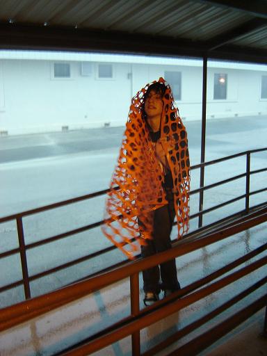 Tyler using his blanket to keep the wind and rain out